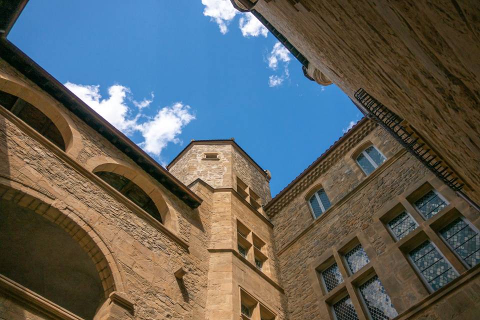 Aubenas Castle in the Ardèche, with a view of the tower and the blue sky dotted with a few white clouds  / Photo: Ardèche en Douce