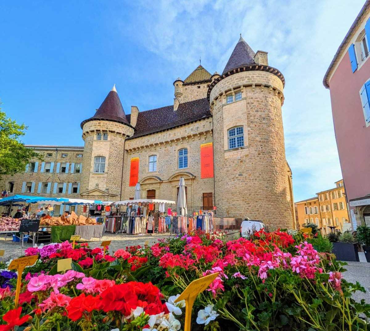 Marché d'Aubenas sur la place du château avec des fleurs et commerces