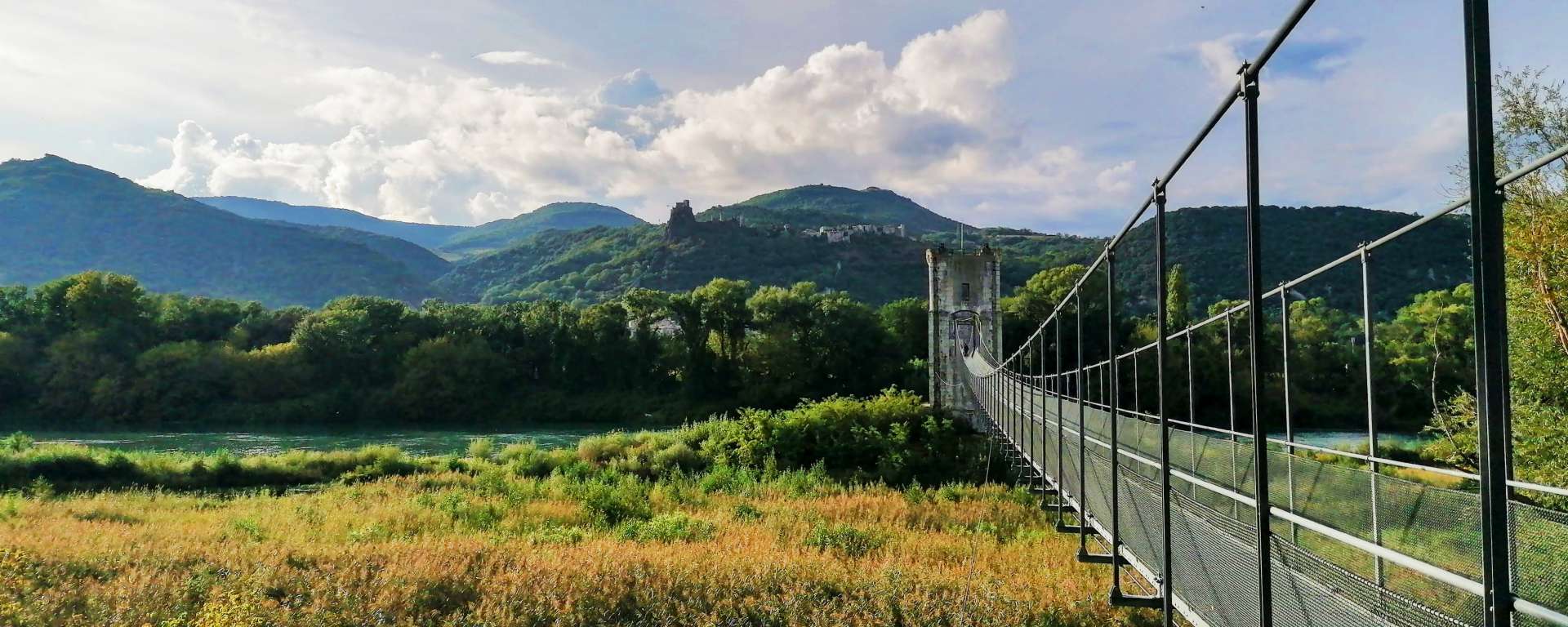 Vue sur la passerelle de Rochemaure, le château sur son promontoire et les montagnes du Vivarais
