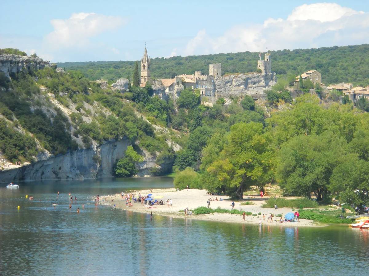 Plage de Saint-Martin en Ardèche avec vue sur le village qui sruplombe la rivère