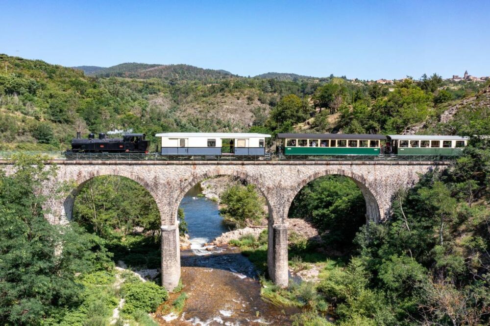 Train à vapeur sur un pont au dessus d'une rivière en Ardèche